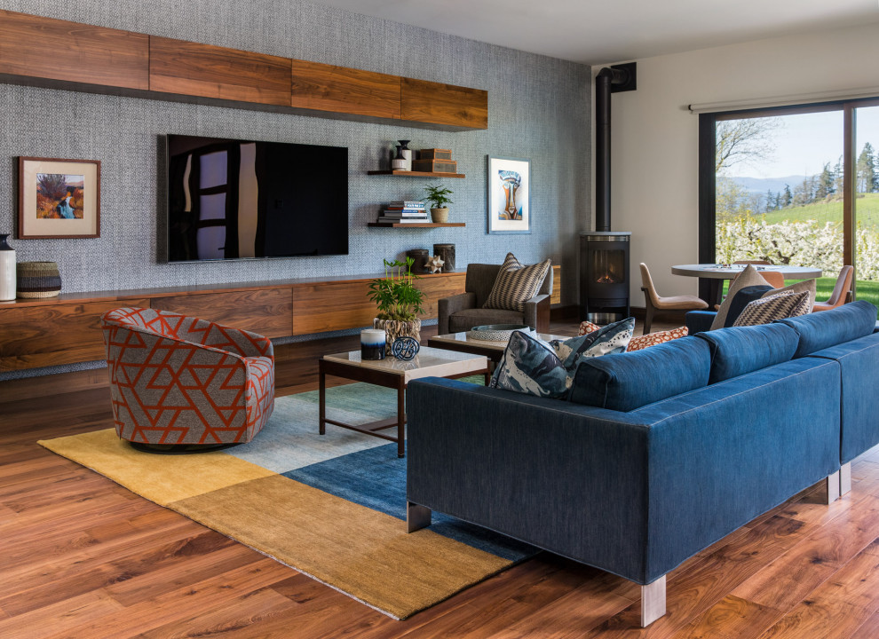 Foto di un soggiorno stile rurale di medie dimensioni e aperto con sala giochi, pareti blu, TV a parete, parquet scuro, stufa a legna e pavimento marrone
