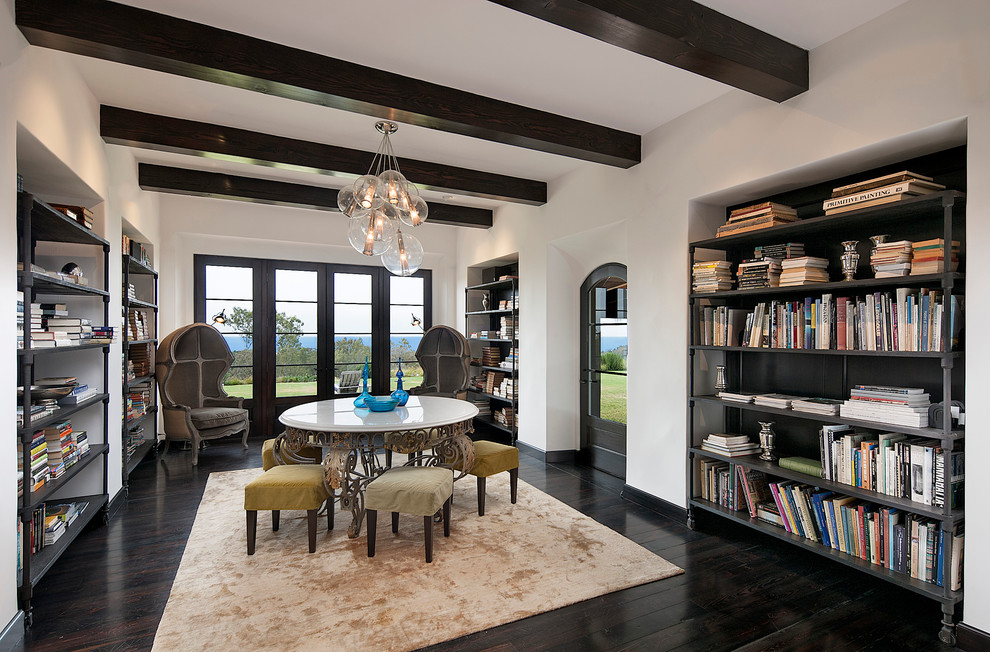 Modelo de sala de estar con biblioteca cerrada mediterránea grande sin chimenea y televisor con paredes blancas y suelo de madera oscura