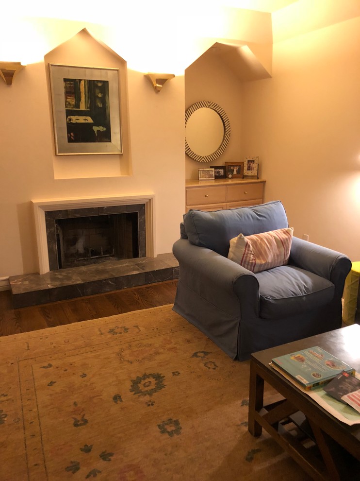 Cette image montre une grande salle de séjour design avec un mur blanc, parquet foncé, une cheminée standard, un manteau de cheminée en pierre et un sol marron.