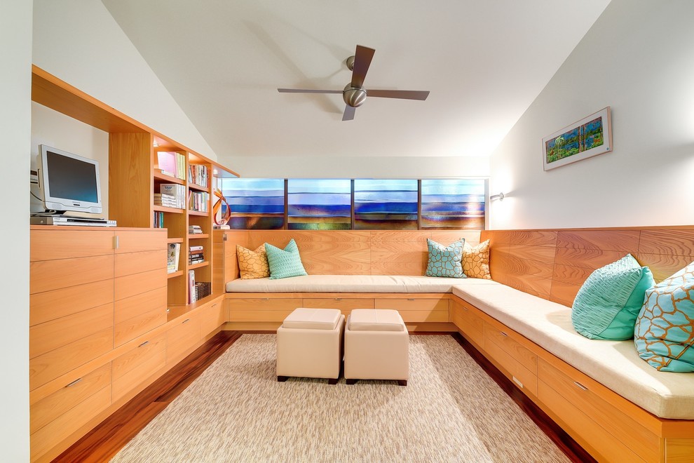 Immagine di un soggiorno minimalista di medie dimensioni con libreria, pareti bianche, pavimento in legno massello medio, nessun camino, parete attrezzata e tappeto