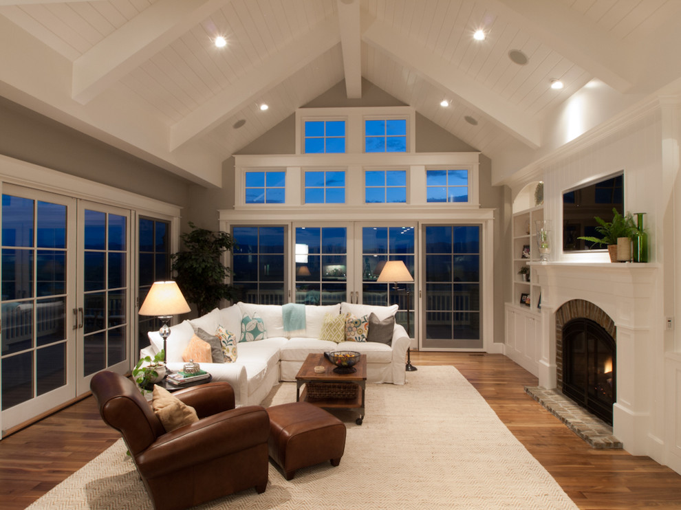 Example of a classic family room design in Denver with a brick fireplace and gray walls
