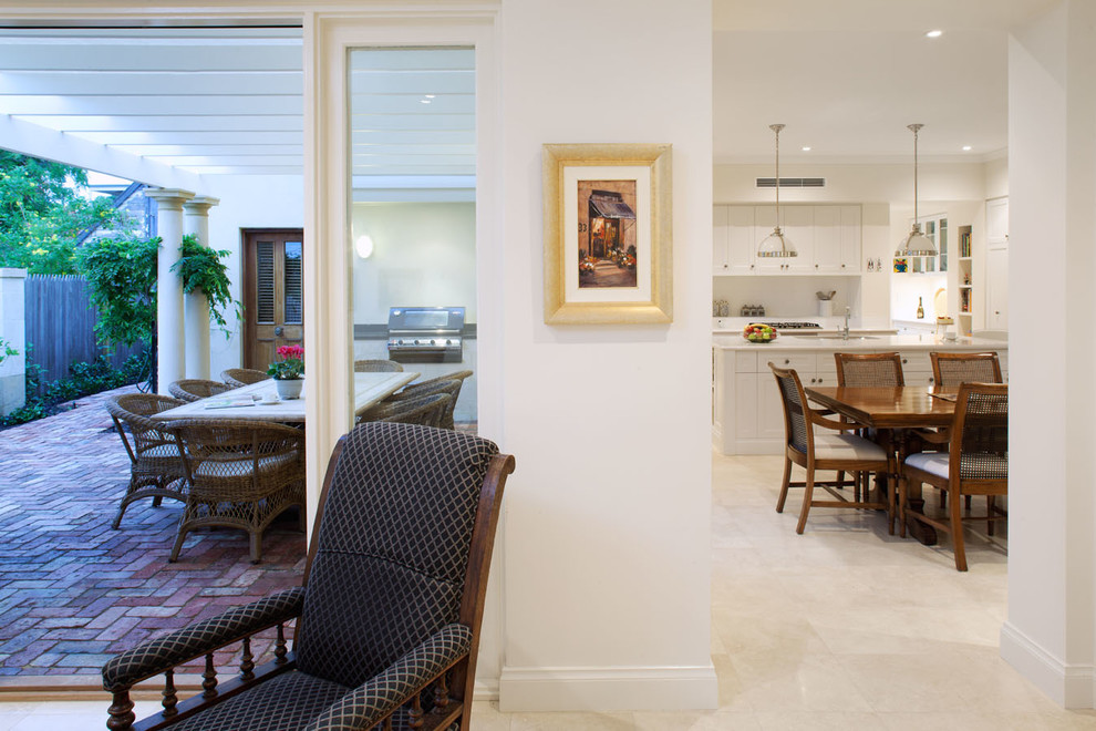 Imagen de sala de estar abierta clásica de tamaño medio sin chimenea con paredes blancas y suelo beige