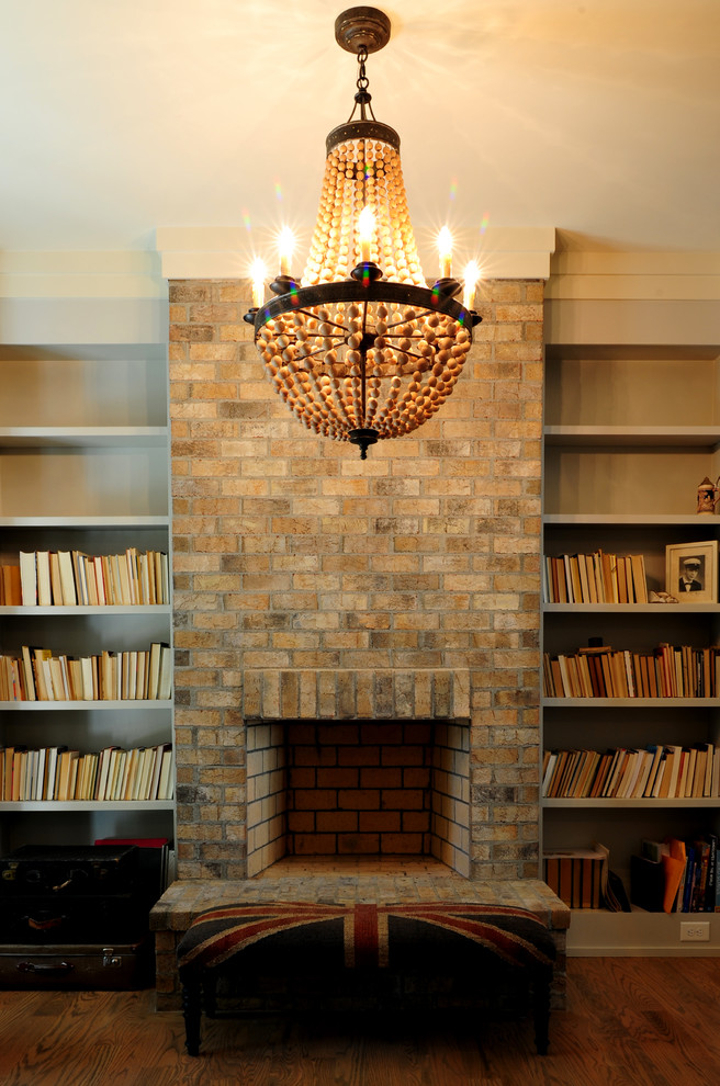 Idée de décoration pour une salle de séjour craftsman fermée avec une bibliothèque ou un coin lecture, un mur gris, parquet foncé, une cheminée standard, un manteau de cheminée en brique et aucun téléviseur.