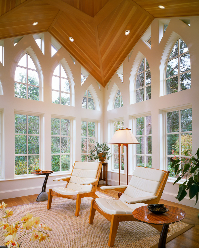 Diseño de sala de estar actual con paredes blancas y suelo de madera en tonos medios