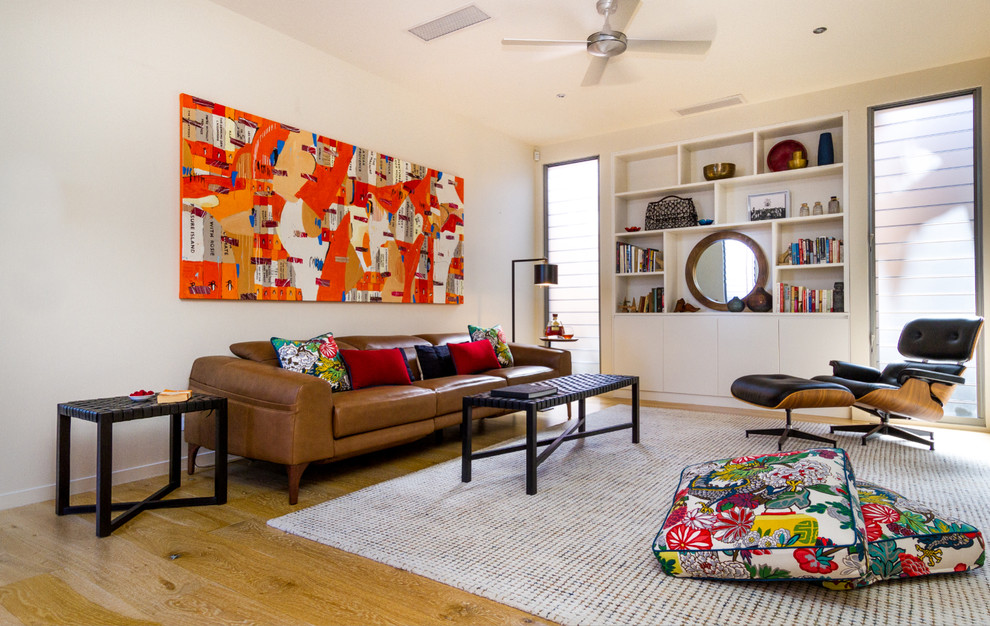 Immagine di un soggiorno boho chic di medie dimensioni e aperto con pareti bianche, pavimento in legno massello medio e pavimento marrone