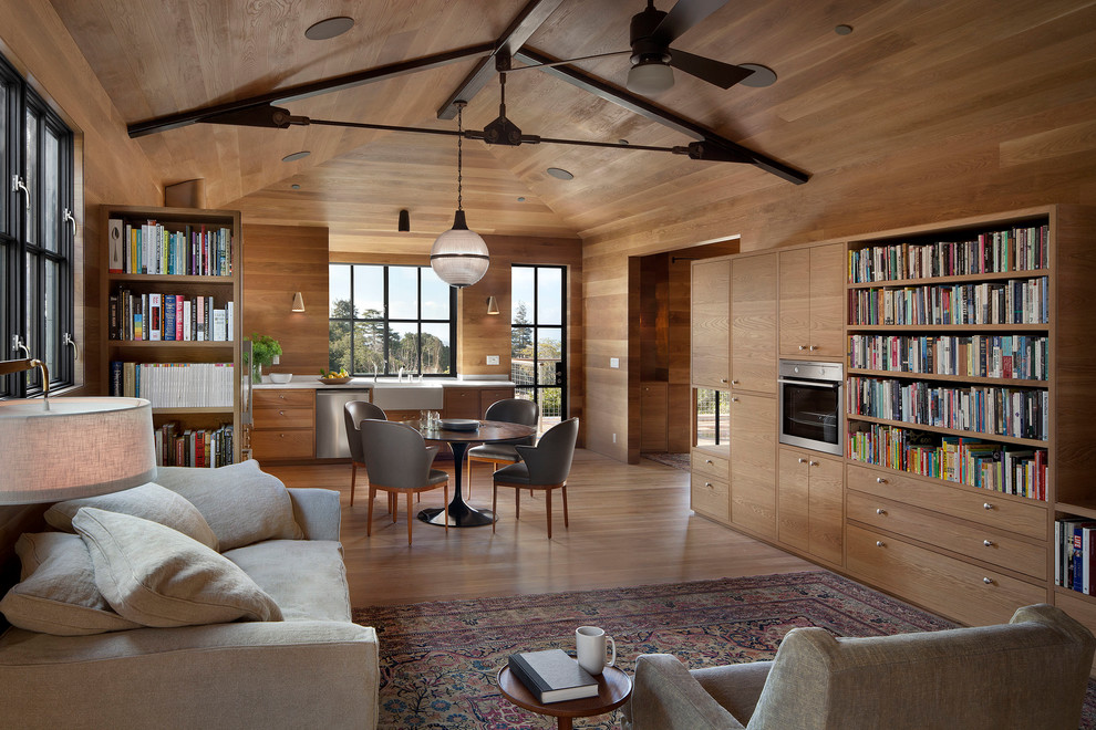 Foto de sala de estar abierta actual con suelo de madera clara