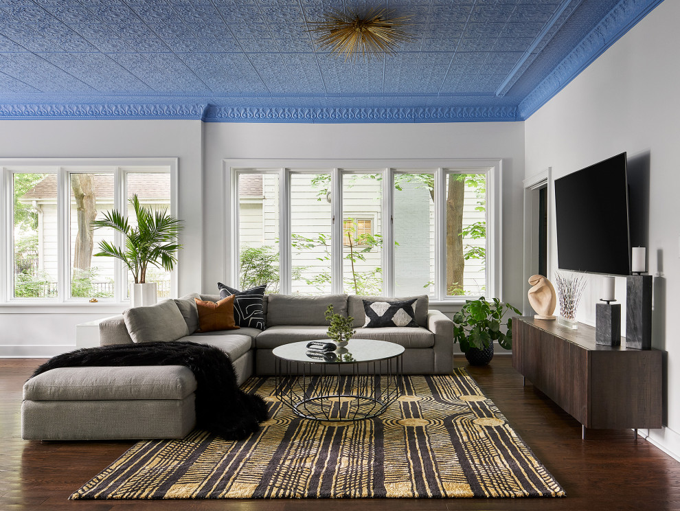 Diseño de sala de estar abierta actual grande con paredes blancas y televisor colgado en la pared