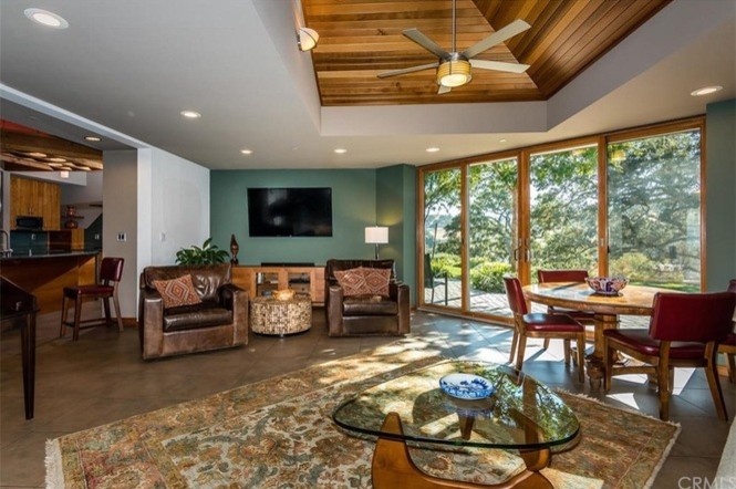 Foto de sala de estar abierta contemporánea con paredes verdes, suelo de baldosas de porcelana y suelo marrón