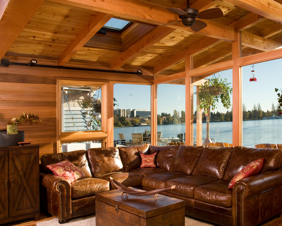 Esempio di un grande soggiorno chic aperto con pavimento in legno massello medio e TV a parete