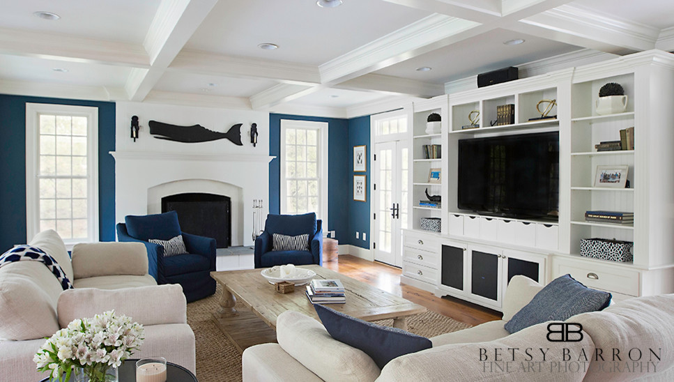 Foto de sala de estar abierta tradicional extra grande con paredes azules, suelo de madera en tonos medios, todas las chimeneas, marco de chimenea de hormigón y pared multimedia