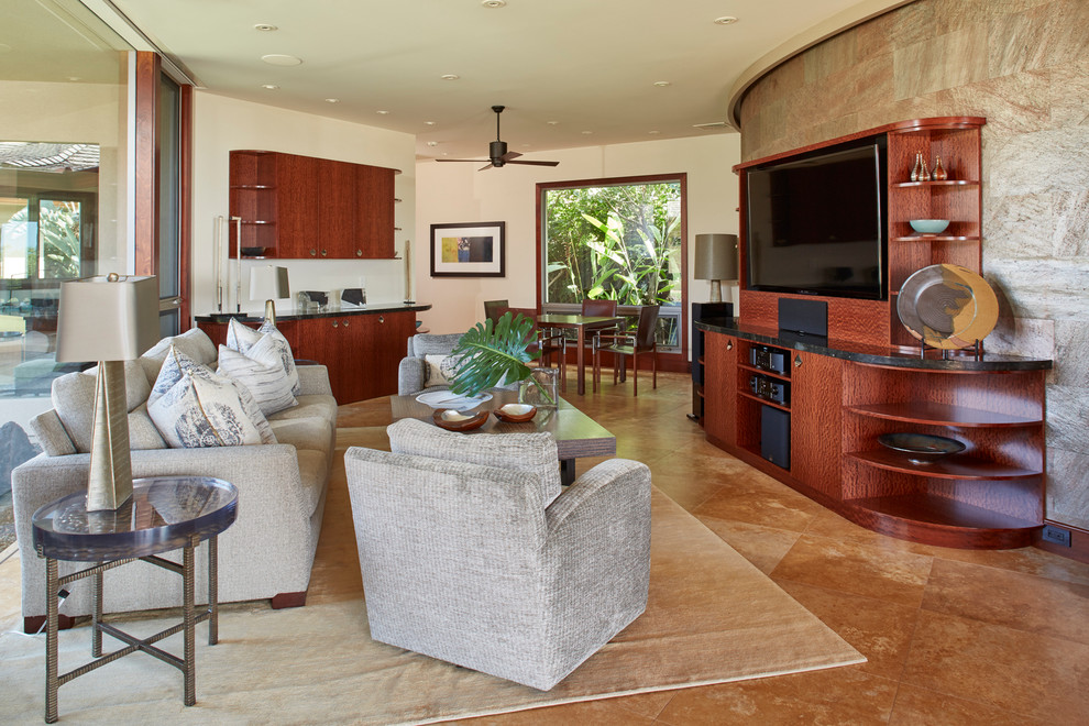 Example of a large island style enclosed travertine floor game room design in Hawaii with a media wall