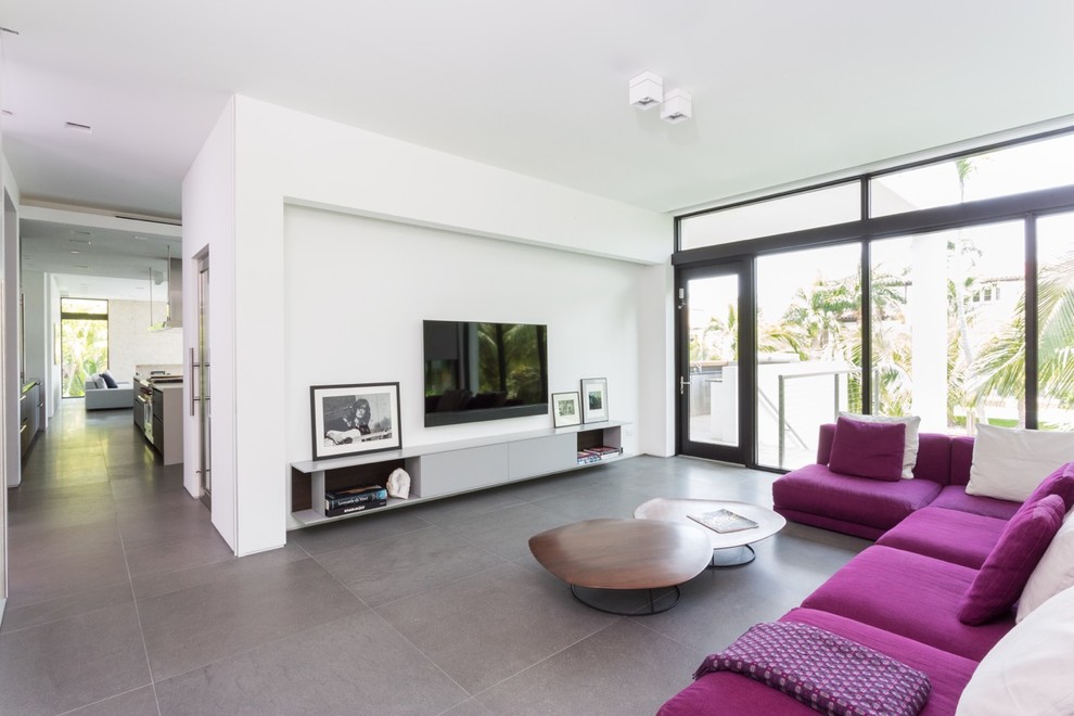 Immagine di un soggiorno design chiuso con libreria, pareti bianche, TV a parete e pavimento grigio