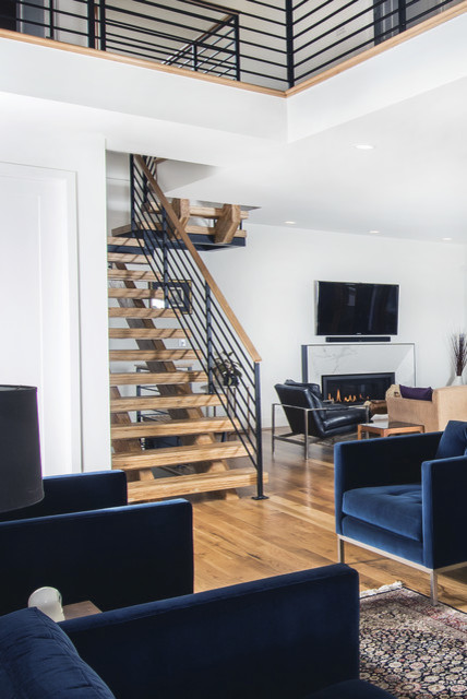 Modelo de sala de estar abierta contemporánea de tamaño medio sin chimenea y televisor con paredes amarillas, suelo de madera en tonos medios y suelo marrón