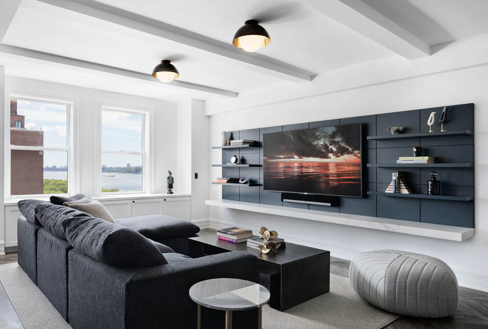 Свежая идея для дизайна: гостиная комната в современном стиле с белыми стенами, темным паркетным полом, телевизором на стене, коричневым полом и ковром на полу без камина - отличное фото интерьера