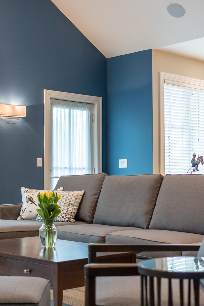 Imagen de sala de estar abierta contemporánea grande sin chimenea con paredes azules, suelo de madera en tonos medios, pared multimedia y suelo marrón