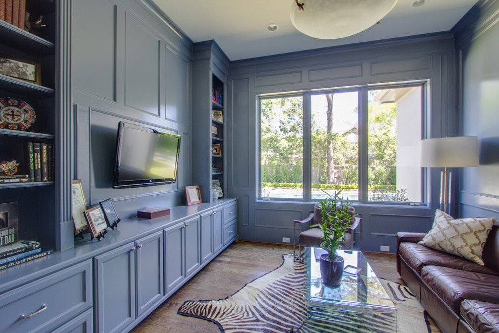 Пример оригинального дизайна: изолированная гостиная комната в стиле неоклассика (современная классика) с синими стенами, паркетным полом среднего тона и телевизором на стене без камина
