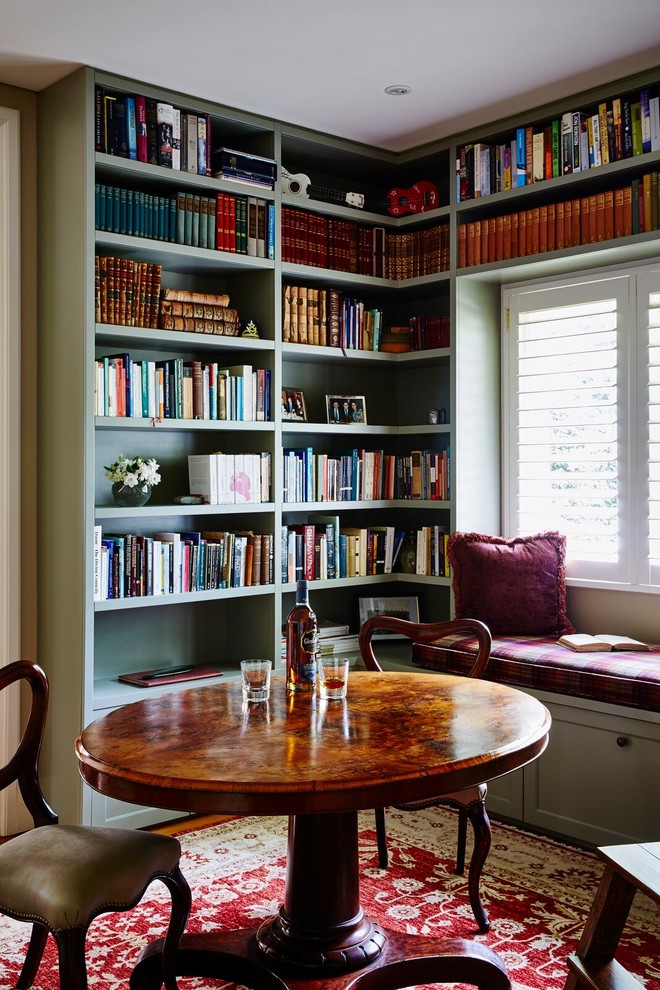 Réalisation d'une salle de séjour tradition avec une bibliothèque ou un coin lecture, un mur vert et un sol en bois brun.