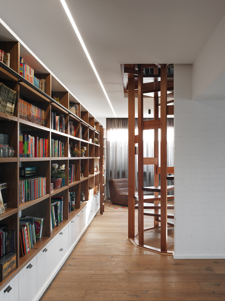 Diseño de sala de estar con biblioteca abierta retro extra grande con paredes blancas, suelo de madera clara y suelo marrón