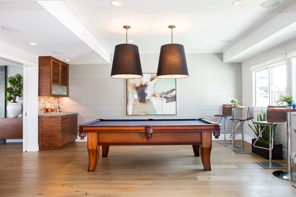 Game room - mid-sized contemporary open concept medium tone wood floor and brown floor game room idea in Orange County with gray walls, no fireplace and a concealed tv