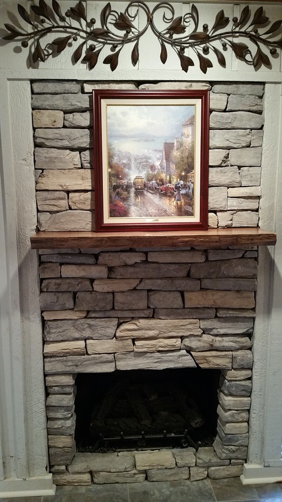 Foto di un soggiorno chic con camino classico e cornice del camino in pietra