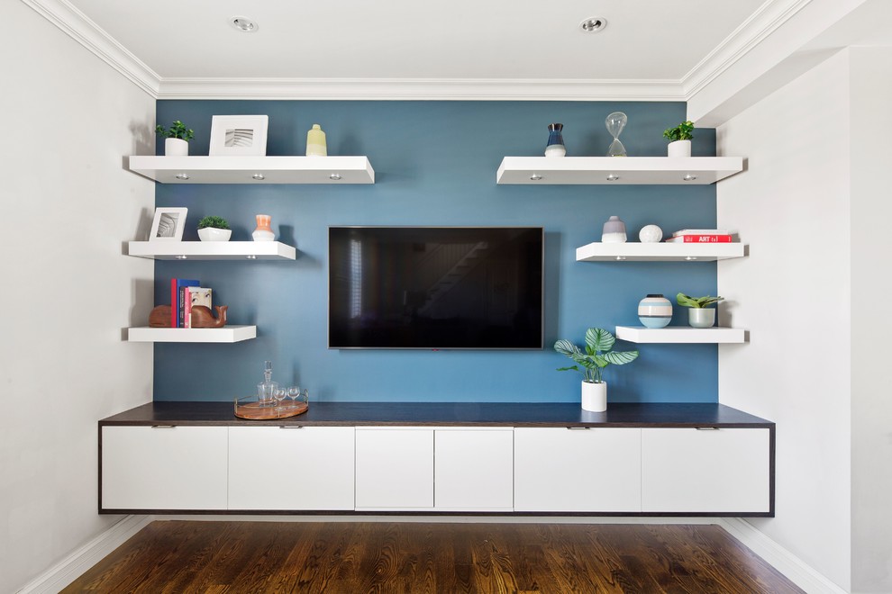 Modelo de sala de estar abierta minimalista pequeña con paredes azules, suelo de madera en tonos medios, televisor colgado en la pared y suelo marrón