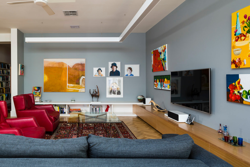 Modelo de sala de estar ecléctica con paredes grises, suelo de madera en tonos medios y televisor colgado en la pared
