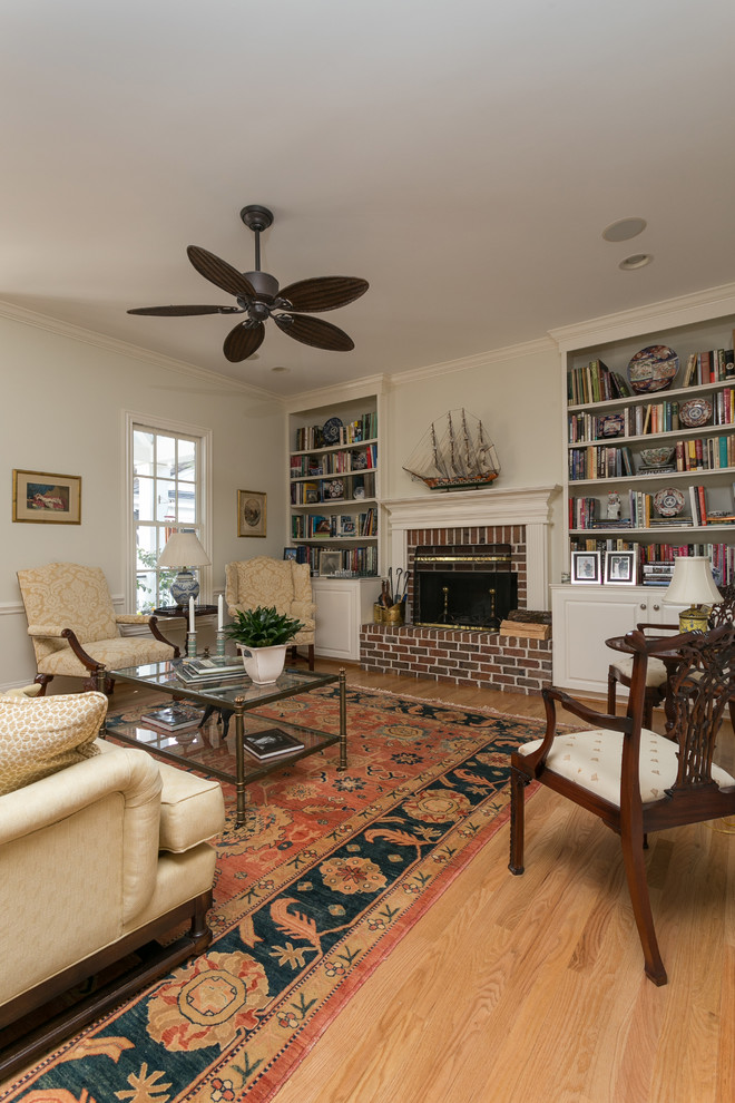 Inspiration for a large traditional open plan games room in Charleston with beige walls, medium hardwood flooring, a standard fireplace, a brick fireplace surround and brown floors.
