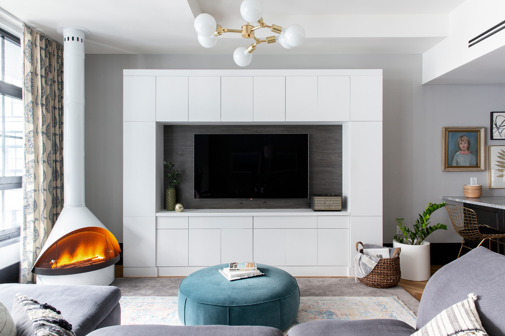 Modelo de sala de estar abierta bohemia con paredes grises, estufa de leña y pared multimedia