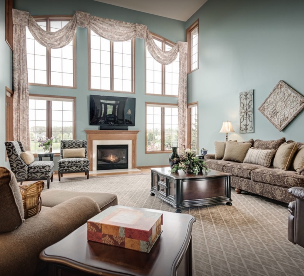 Aménagement d'une grande salle de séjour classique fermée avec un mur bleu, un sol en bois brun, une cheminée standard, un téléviseur indépendant et un sol marron.
