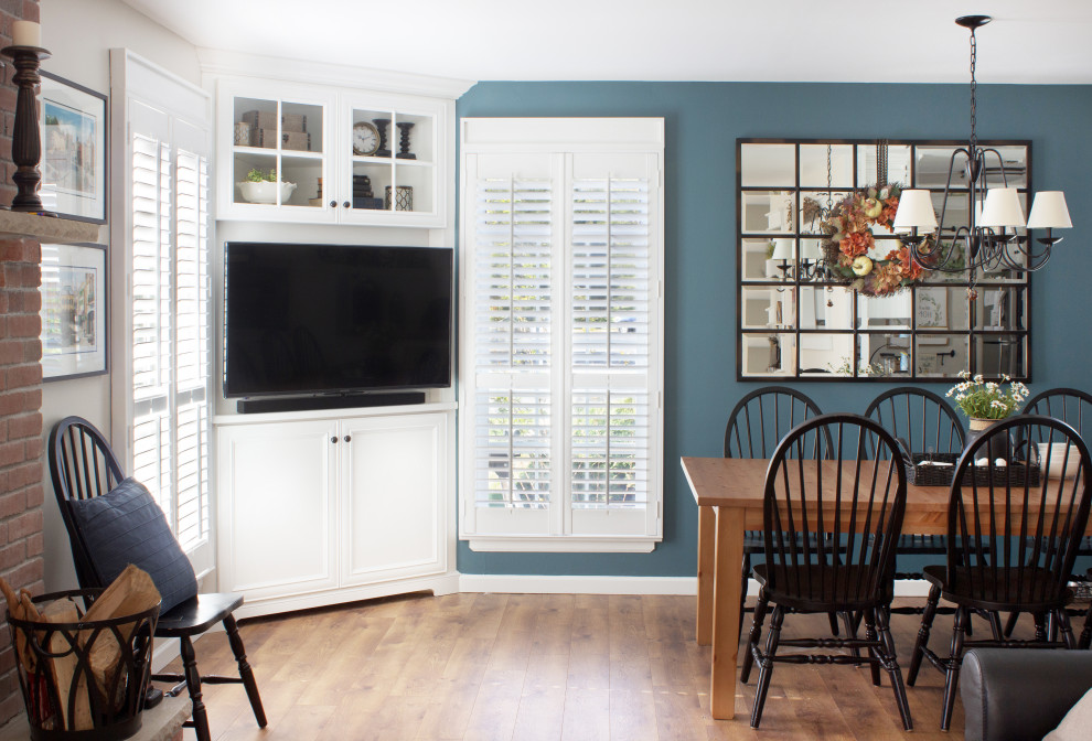 Kleines, Offenes Klassisches Wohnzimmer mit blauer Wandfarbe, braunem Holzboden, Eck-TV und braunem Boden in New York