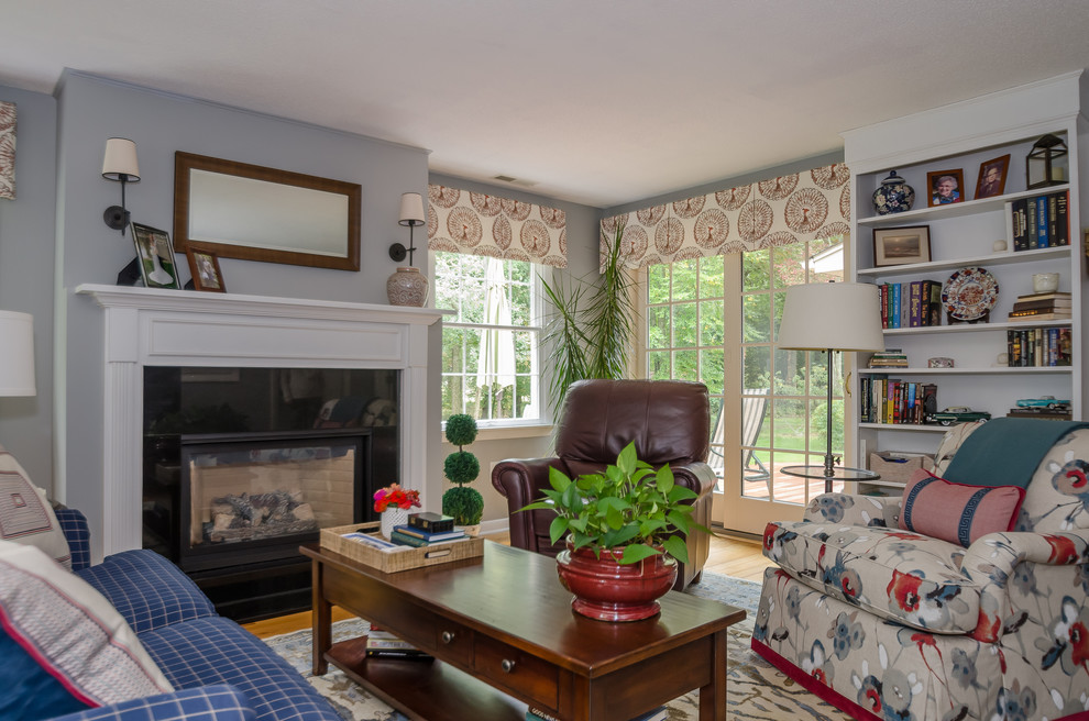 Exemple d'une petite salle de séjour chic fermée avec un mur bleu, parquet clair, une cheminée standard, un manteau de cheminée en bois et un téléviseur indépendant.