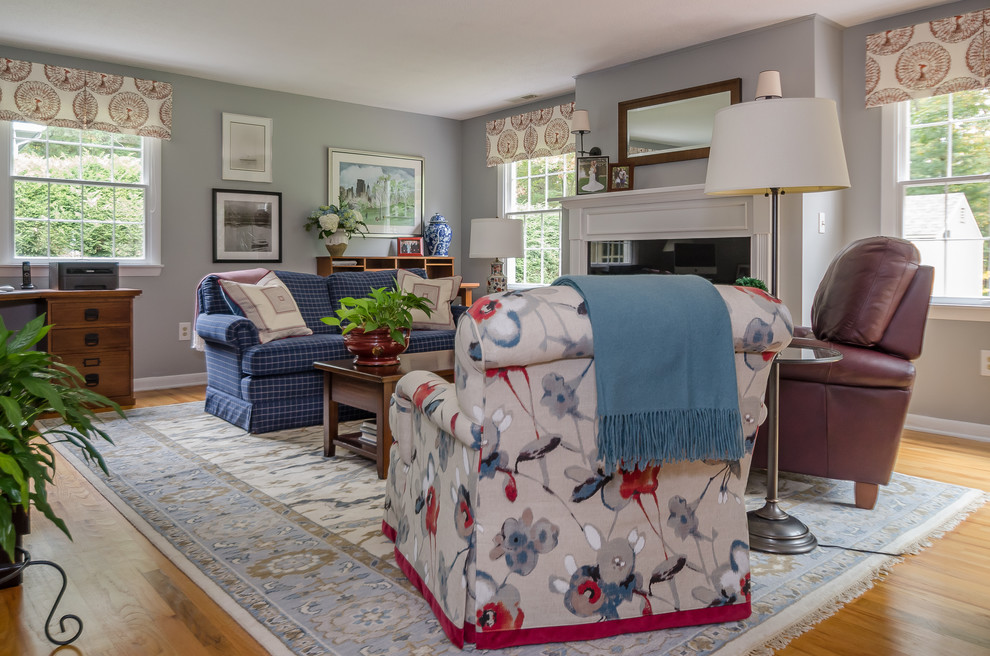 Kleines, Abgetrenntes Klassisches Wohnzimmer mit blauer Wandfarbe, hellem Holzboden, Kamin, Kaminumrandung aus Holz und freistehendem TV in Bridgeport
