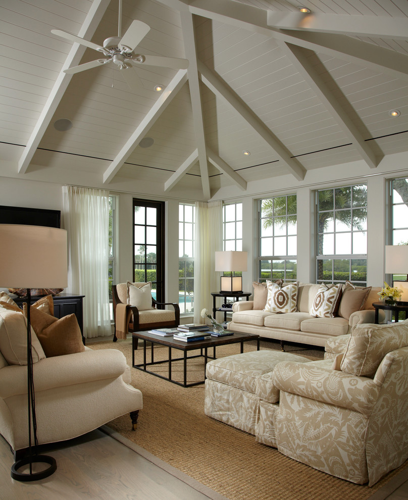 Ejemplo de sala de estar clásica grande con paredes blancas, suelo de madera clara y televisor colgado en la pared