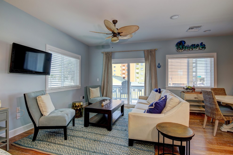 Стильный дизайн: открытая гостиная комната среднего размера в морском стиле с синими стенами, полом из бамбука и телевизором на стене без камина - последний тренд