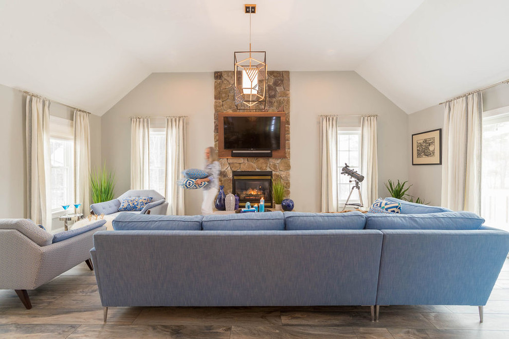 Idée de décoration pour une salle de séjour minimaliste de taille moyenne et ouverte avec un mur gris, un sol en carrelage de porcelaine, une cheminée standard, un manteau de cheminée en pierre, un téléviseur fixé au mur et un sol bleu.
