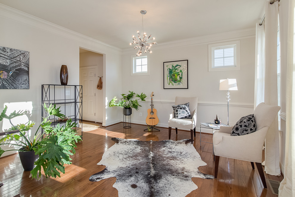 Immagine di un soggiorno chic con pareti bianche e pavimento in legno massello medio