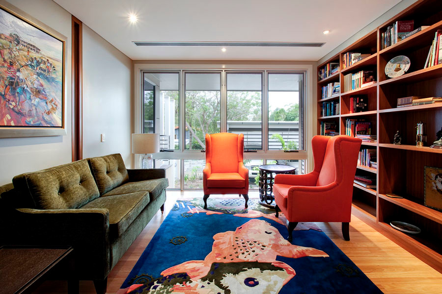 Ejemplo de sala de estar con biblioteca cerrada actual extra grande sin chimenea y televisor con paredes beige, suelo de madera clara y suelo marrón