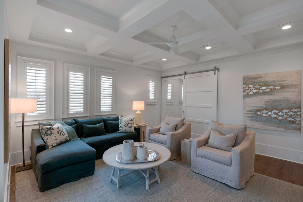 Example of a beach style enclosed light wood floor family room design in Miami with white walls, no fireplace and a wall-mounted tv