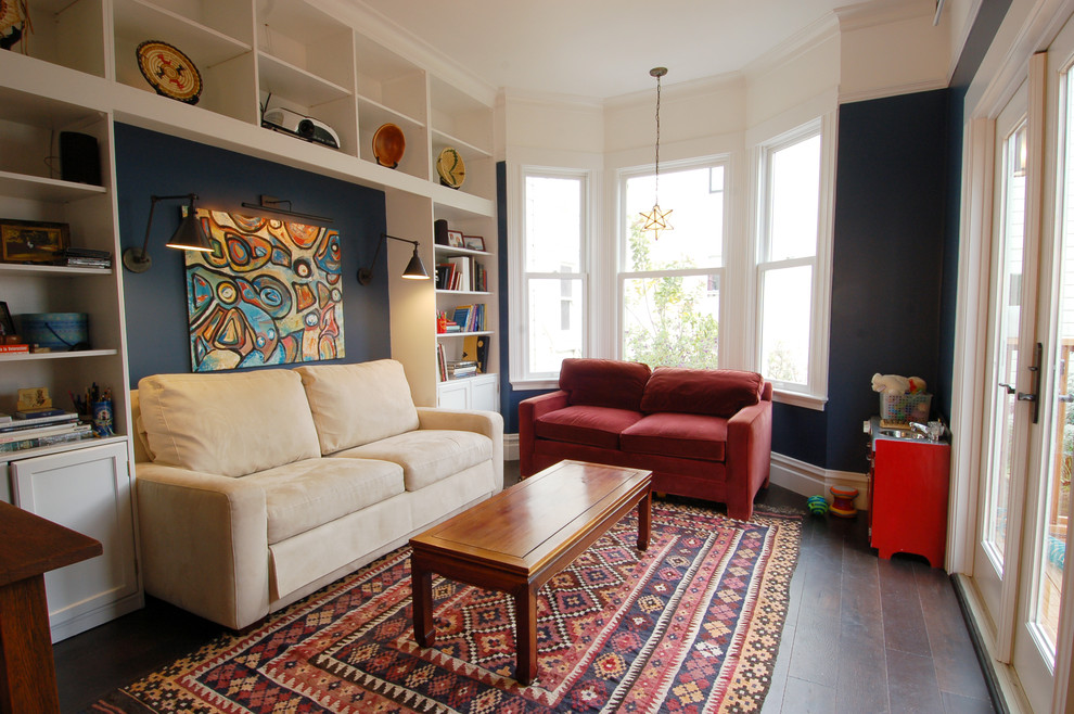 Cette image montre une salle de séjour bohème avec parquet foncé et un mur bleu.