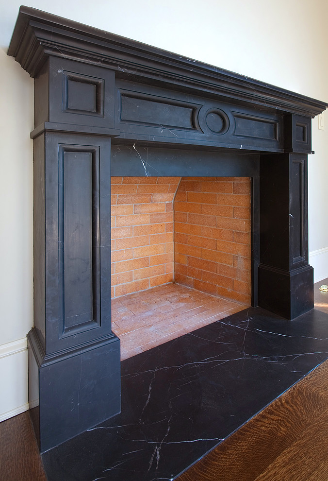 Cette image montre une salle de séjour craftsman avec une cheminée standard et un manteau de cheminée en pierre.