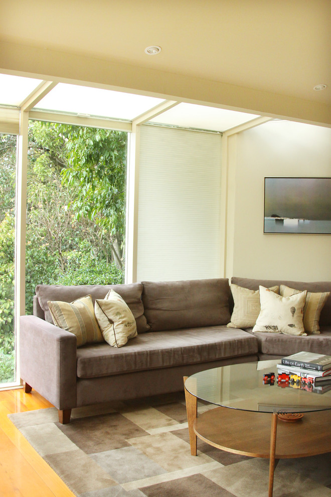 Medium sized eclectic enclosed games room in Melbourne with beige walls, medium hardwood flooring and a wall mounted tv.