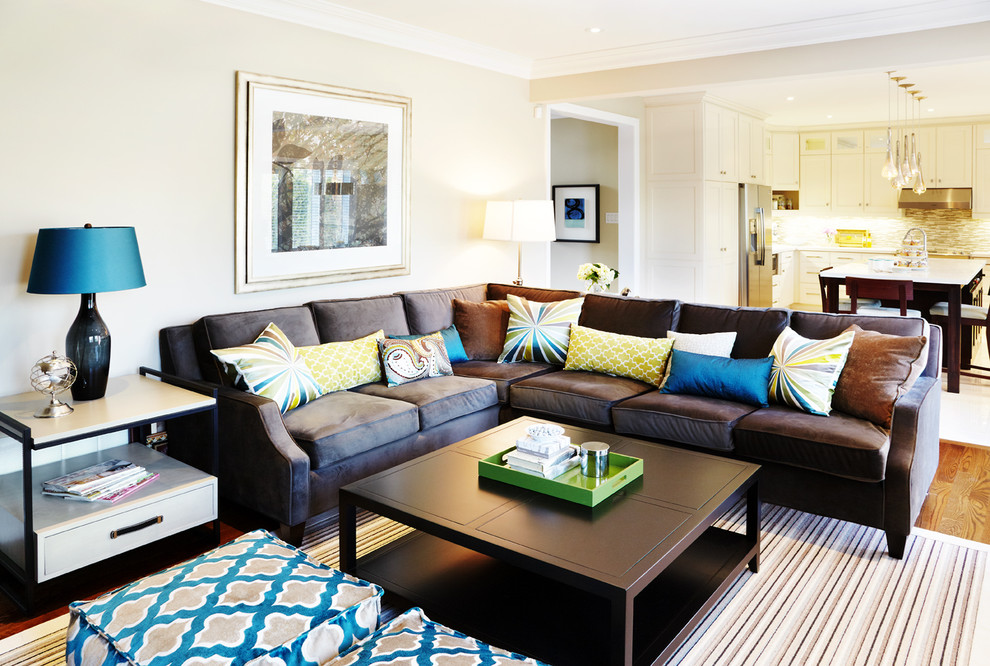 Идея дизайна: открытая гостиная комната в классическом стиле с бежевыми стенами, коричневым диваном и ковром на полу