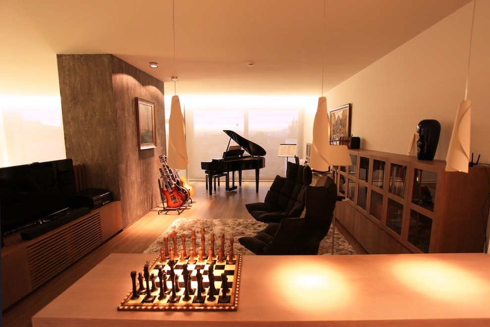 Idee per un grande soggiorno minimalista aperto con sala della musica, pareti bianche, pavimento in legno massello medio, nessun camino e parete attrezzata