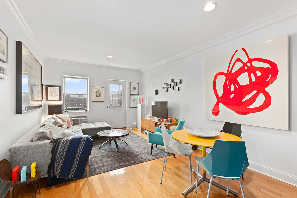 Abgetrenntes Modernes Wohnzimmer mit weißer Wandfarbe, braunem Holzboden und gelbem Boden in New York