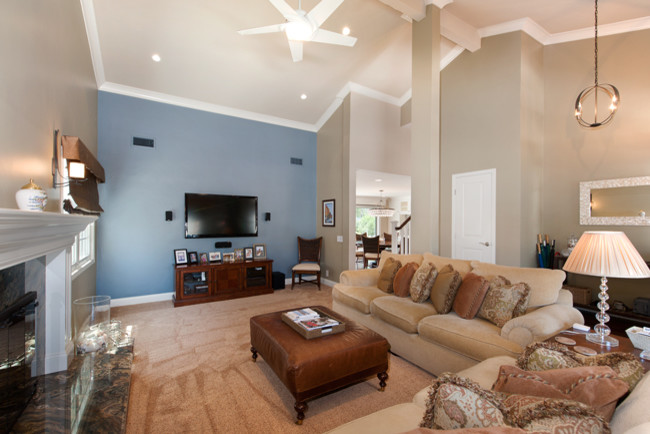 Example of a large transitional open concept dark wood floor and blue floor family room design in Orange County with a standard fireplace, a wood fireplace surround and a wall-mounted tv