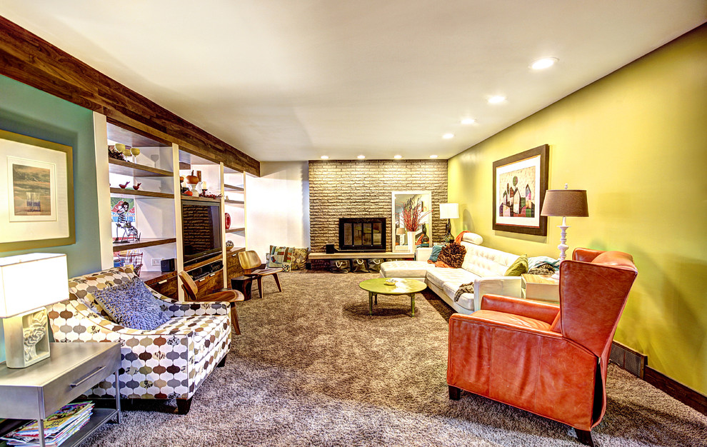 На фото: гостиная комната в стиле фьюжн с ковровым покрытием, стандартным камином, фасадом камина из камня, мультимедийным центром, разноцветными стенами и акцентной стеной