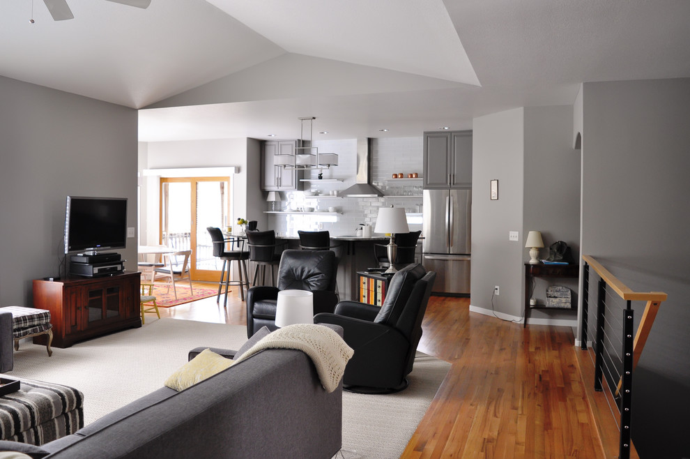 Идея дизайна: открытая гостиная комната среднего размера в стиле модернизм с серыми стенами, паркетным полом среднего тона, отдельно стоящим телевизором, стандартным камином и фасадом камина из камня