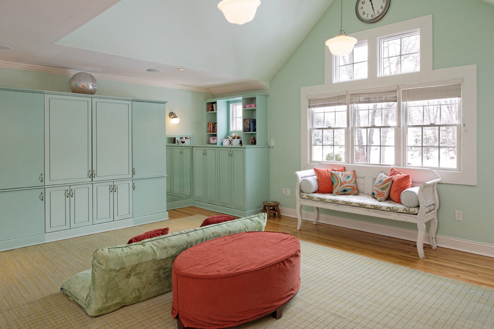 Exemple d'une salle de séjour chic de taille moyenne et ouverte avec parquet clair, un téléviseur dissimulé, un mur bleu, aucune cheminée et un sol marron.