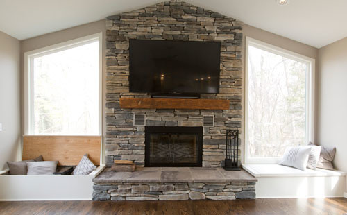 Photo of a large classic open plan games room in Cleveland with grey walls, dark hardwood flooring, a standard fireplace, a stone fireplace surround and a wall mounted tv.