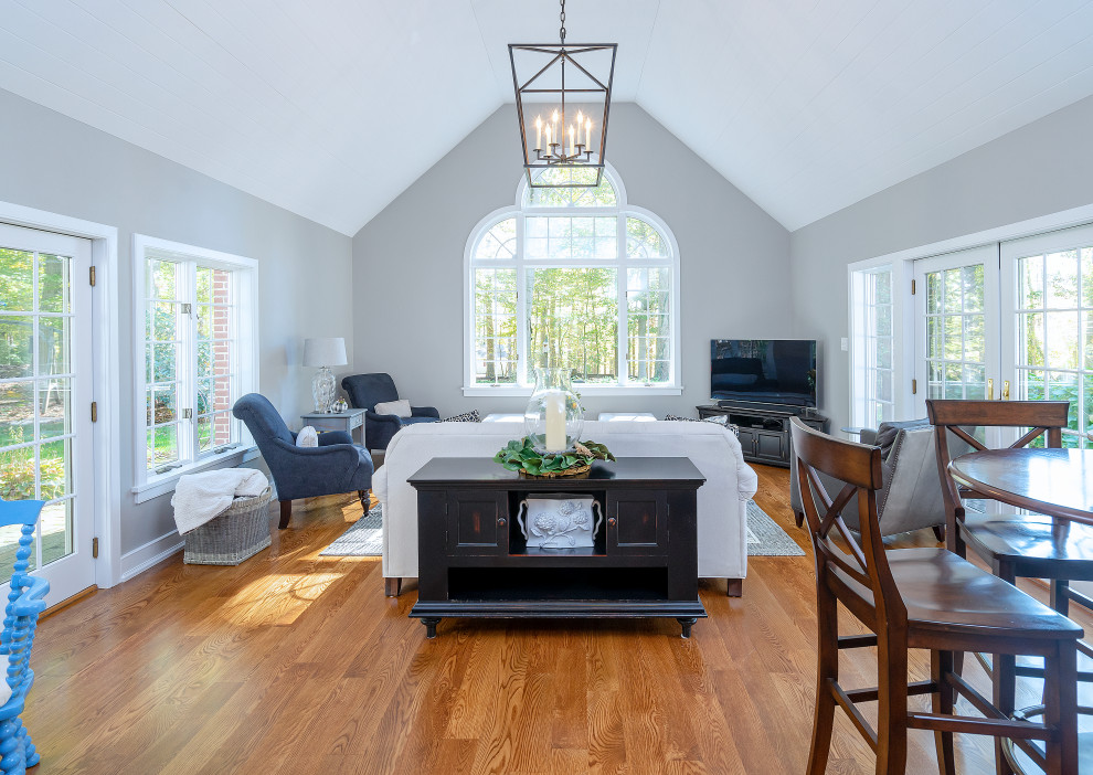 Immagine di un grande soggiorno country chiuso con pareti grigie, pavimento in legno massello medio, pavimento marrone e soffitto in perlinato